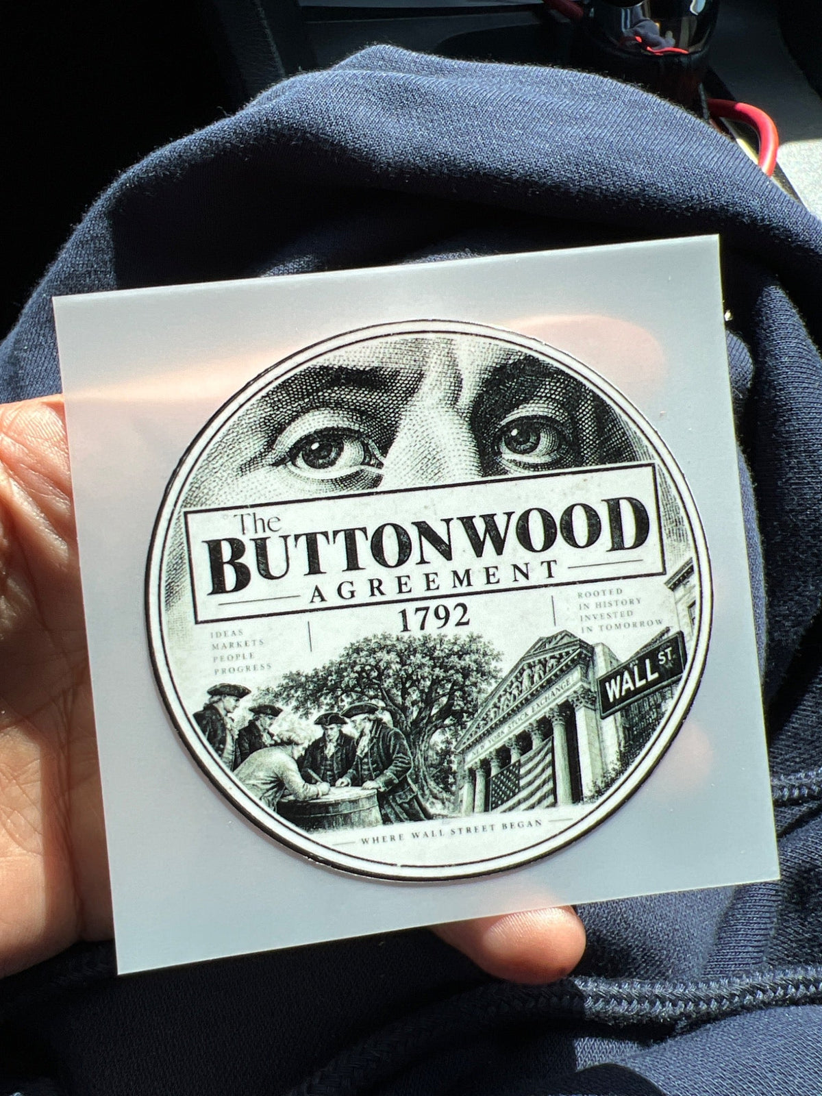 Actual circular Buttonwood Agreement 1792 Wall Street sticker shown in hand